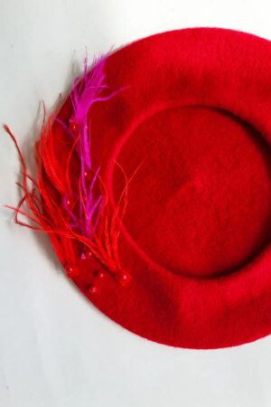 czerwony beret z naszytymi piórami strusia